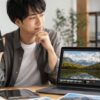 Lightroomのスマホ版とPC版の違いを比較しながら写真編集を行う日本人男性